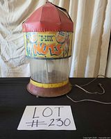 Full view of machine showing dome top, advertising band, clear cylinder, rusted base and power cord