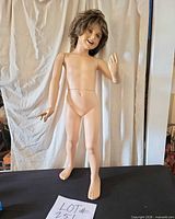 Full-length view of standing child mannequin on table