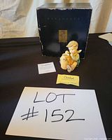 Front view of figurine with box, certificate, control card visible