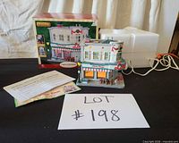 Full lot showing lighted building, box, styrofoam, instruction sheet and cord
