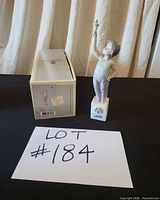 Figurine beside original box with lot card visible