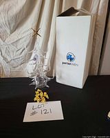 Full view of glass Christmas tree candelabra with star topper, candles, gold bell ornaments, and original Parisevetro box