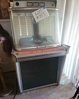 Full view of vintage jukebox showing cabinet, dome, speaker grille