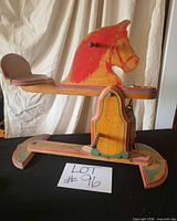 left-side view of entire wooden spring rocking horse showing painted mane, seat, base and lot number
