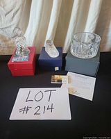 Bell, shoe figurine, bonbon bowl each on respective original boxes with documentation displayed