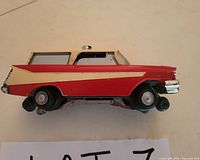 Passenger side view of Lionel 68 Executive Inspection Car showing red and cream paint, wheels, and underside truck assembly