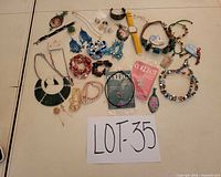 Full layout of 30+ jewelry pieces including watch, necklaces, pendants, bracelets