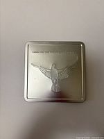 Closed presentation tin showing embossed bird and 1999/2000 dates