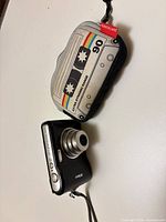 Camera with lens extended beside cassette-style case