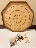 Crokinole side of board with discs, pegs, powder, bag, rules visible