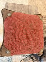 Front view showing red woven face, brown faux-suede corners with metal conchos