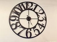 Front view of 36" metal open-face wall clock showing numerals and hands