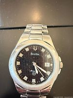 Front view of Bulova Marine Star watch showing black dial, markers, date window, stainless steel bracelet