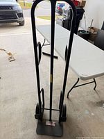 Full front view of black steel hand truck showing twin uprights and toe plate