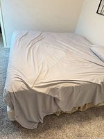 Bed showing overall view with bedding covering mattress and box spring