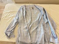 Light blue plaid/check long-sleeve shirt laid open, buttons visible