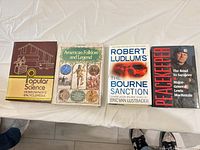 Front covers of four hardcover books aligned on table