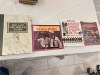 All four books laid out on table showing covers and relative size