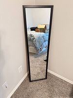 Front view of full-length mirror standing against wall