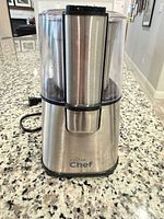 Front view of Master Chef stainless steel grinder with clear lid