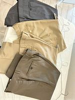 Four pairs of dress trousers laid out showing colors and style