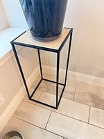 Full view of plant stand showing metal frame and wood top