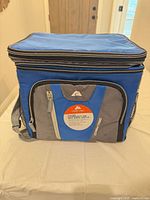 Front view of Ozark Trail soft-sided cooler showing logo, front zip pocket, shoulder strap