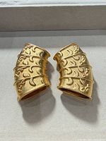 Front view of both gold-tone scarf tubes showing decorative pattern