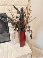Full view of red vase and artificial eucalyptus arrangement