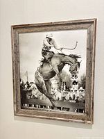 Portrait-oriented rodeo bronc rider print in rustic frame