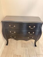 Front view showing three drawers, handles, bombe shape