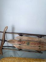 Full view of vintage wooden sled showing deck graphics and runners