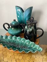 All four turquoise drip glaze ceramic pieces grouped on tabletop