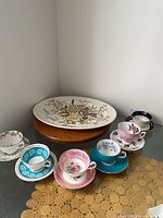 Group shot showing all six teacup & saucer sets around platter
