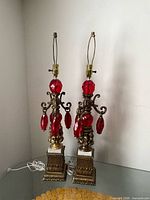 Full view of both lamps on glass table showing bases, bodies, harps, wiring