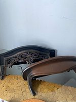 Two brown ornate plastic wall shelves on surface