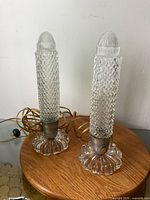 Front view of both clear glass torpedo lamps, cords visible