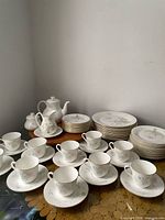 Full set showing cups, saucers, teapot, creamer, sugar, and stacks of plates