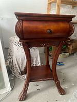 Full view of wooden side table showing drawer, legs, and shelf