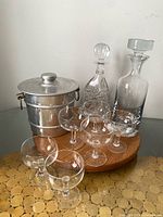 Group shot showing both decanters, ice bucket and five coupes on wooden board