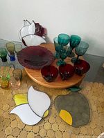 Group shot of all stained glass panels, red mugs, teal stemware, red plate, pastel shot glasses