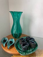 Full lot showing green glass vase, BMP plate, pair of leaf candle holders, six napkin rings