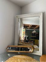 Large white ornate mirror and smaller gold mirror in front