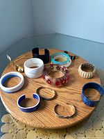 All fifteen bracelets arranged on wooden board