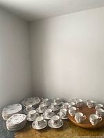 Group view of all Royal Albert Petit Point pieces stacked on table