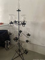 Full view of wrought iron candle holder with glass shades