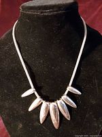 Front view of larger necklace showing seven drop pendants and chain