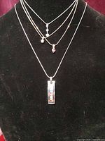 Four necklaces displayed on bust showing relative lengths and pendants