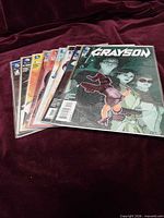 Stack of nine Grayson comics bagged and boarded
