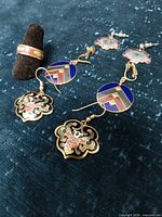 All earrings and ring shown on blue fabric